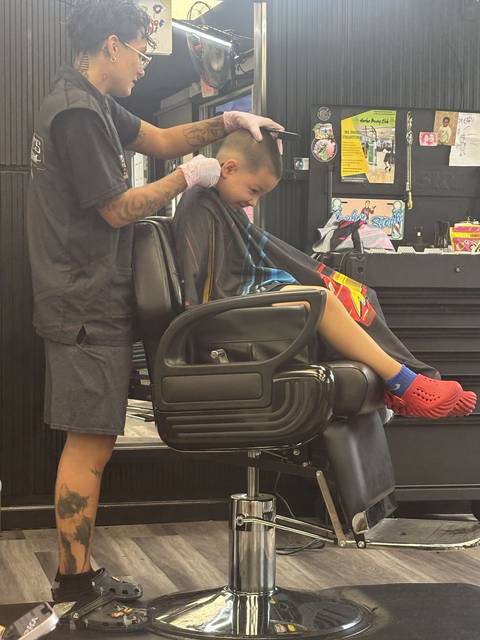 Steph cutting a young client in the studio