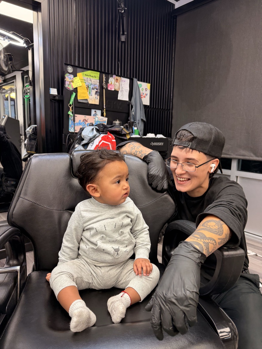 Steph smiling with a toddler in the barber chair
